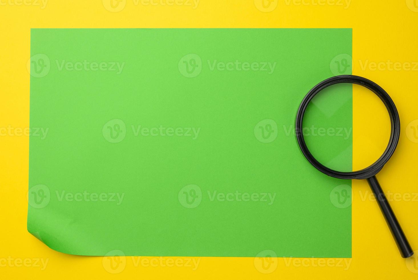 black magnifier on a yellow background. The concept of uncertainty and the search for solutions photo