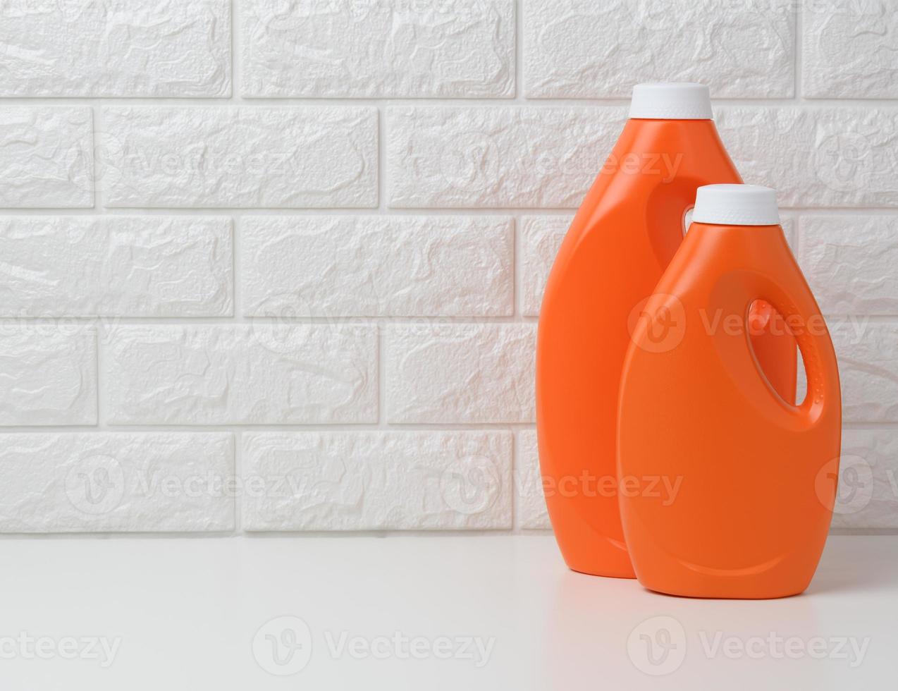 botella de plástico naranja para detergente líquido para ropa sobre fondo blanco foto