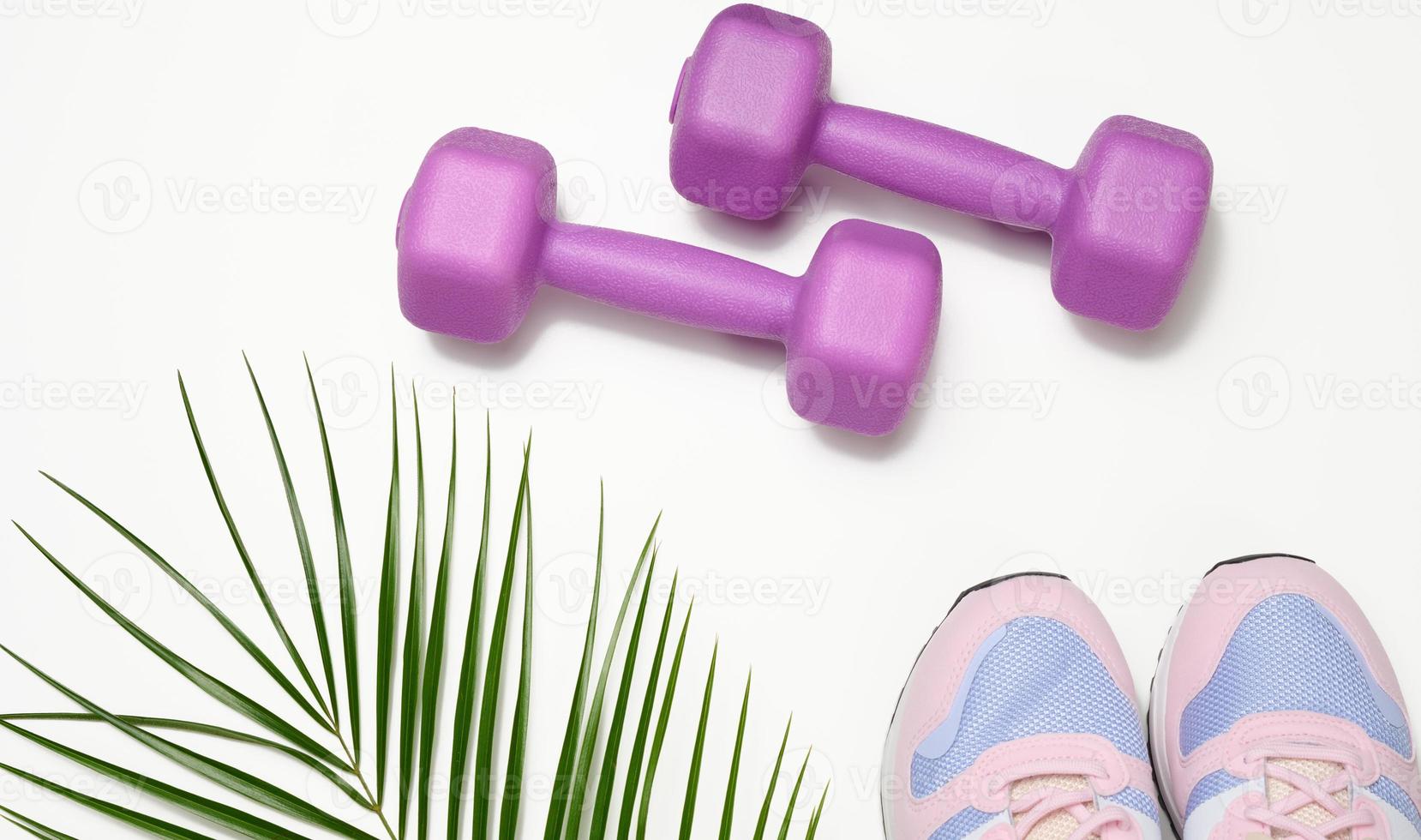 pair of pink sneakers and purple dumbbells on a white background photo