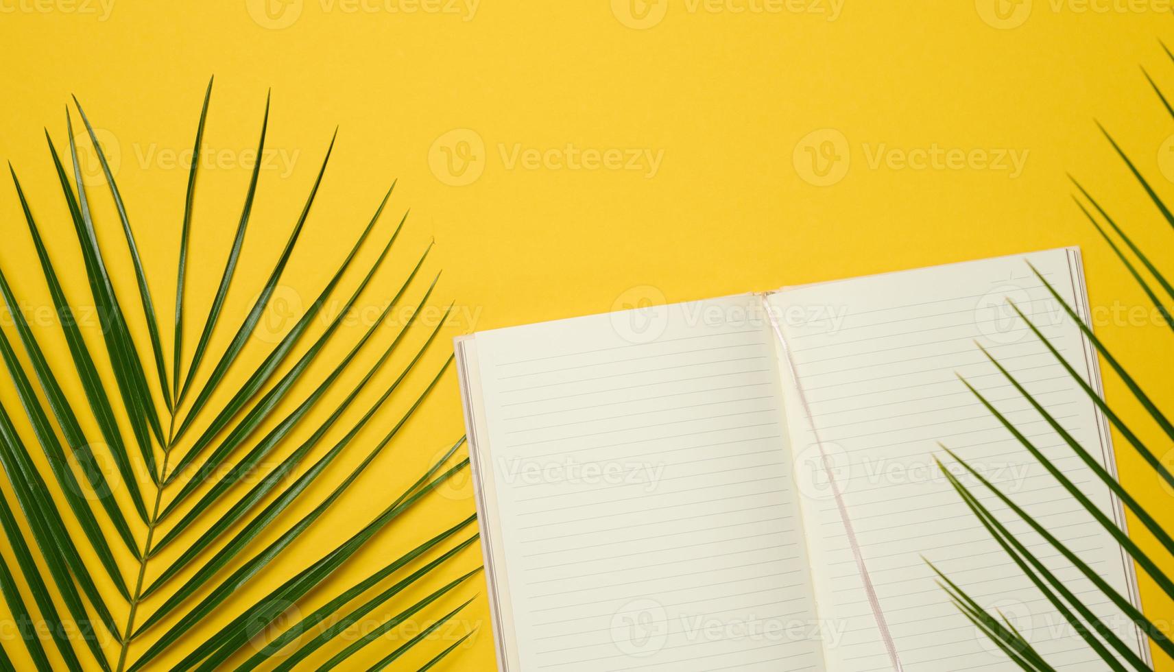 open notebook with blank white sheets on a yellow background, top view. photo