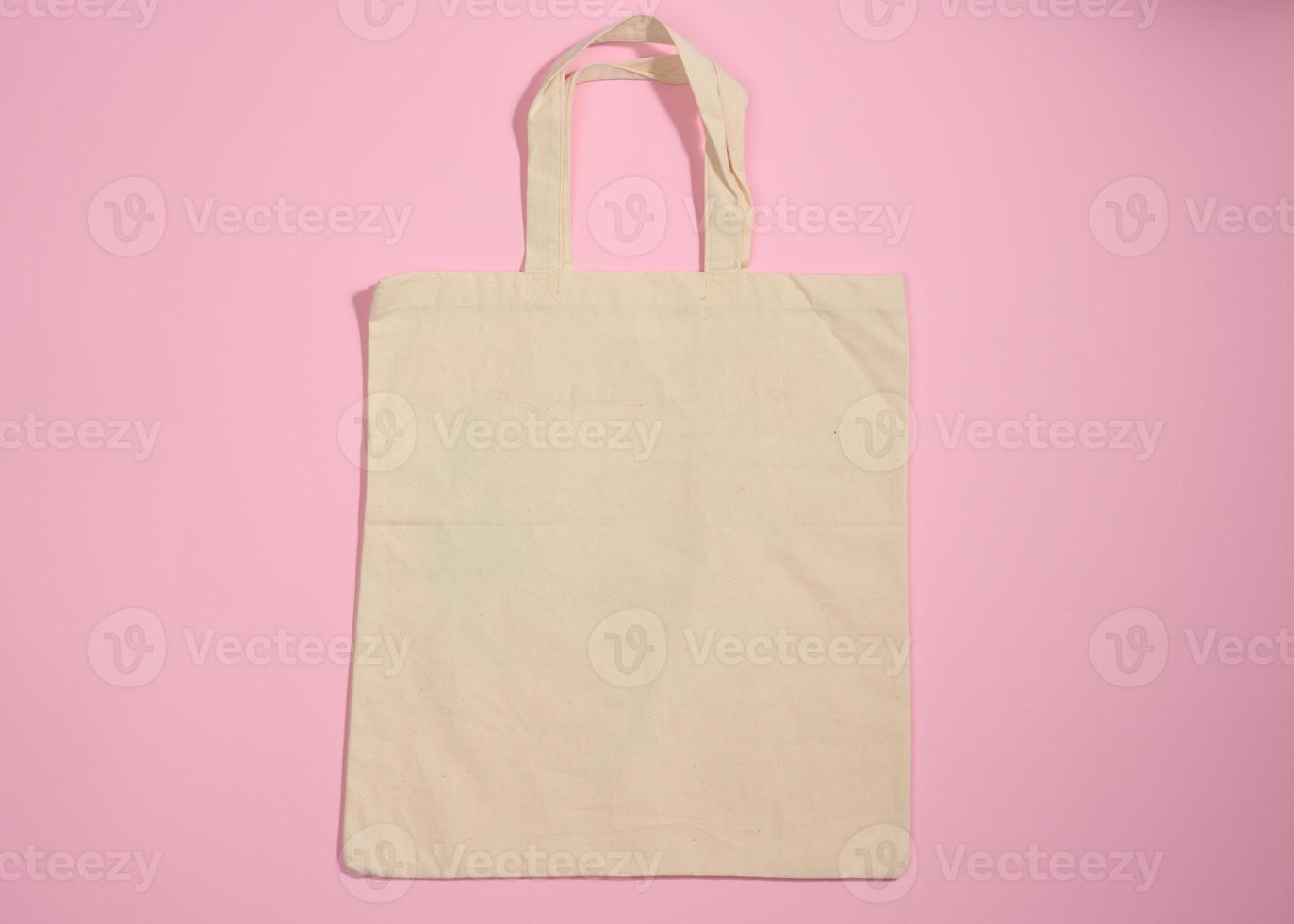 empty linen eco friendly beige canvas tote bag for branding on a pink background. Clear reusable bag for groceries, mock up. Flat lay photo