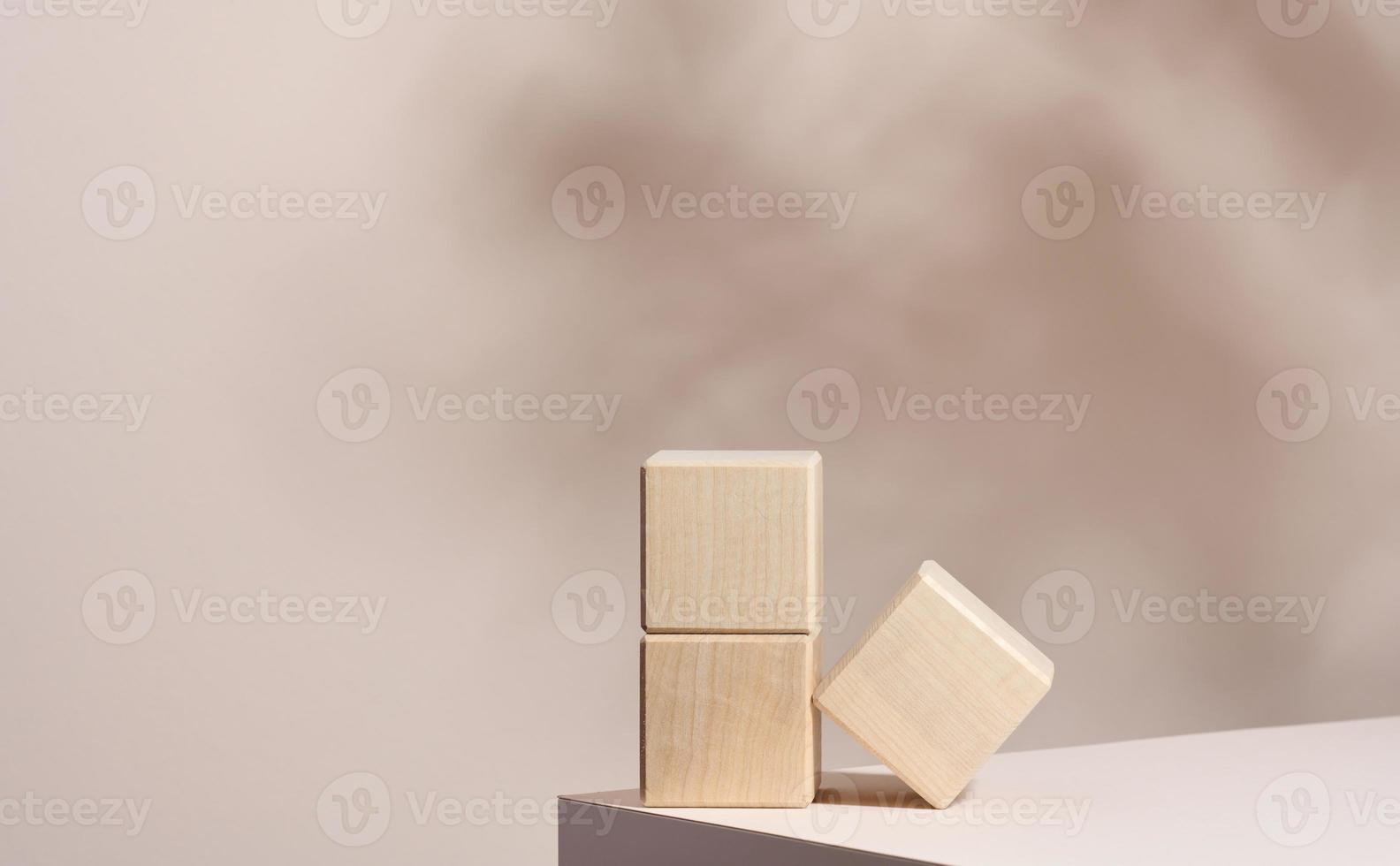 wooden podium to showcase cosmetics and other items, beige background with shadow photo