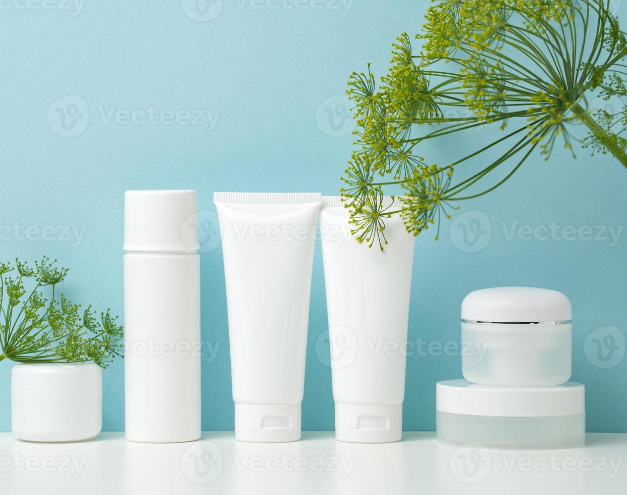 empty white plastic tubes and jars for cosmetics. Packaging for cream, gel, serum, advertising and product promotion photo