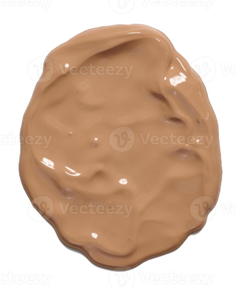 sample of light brown face cream dripping down on white background photo