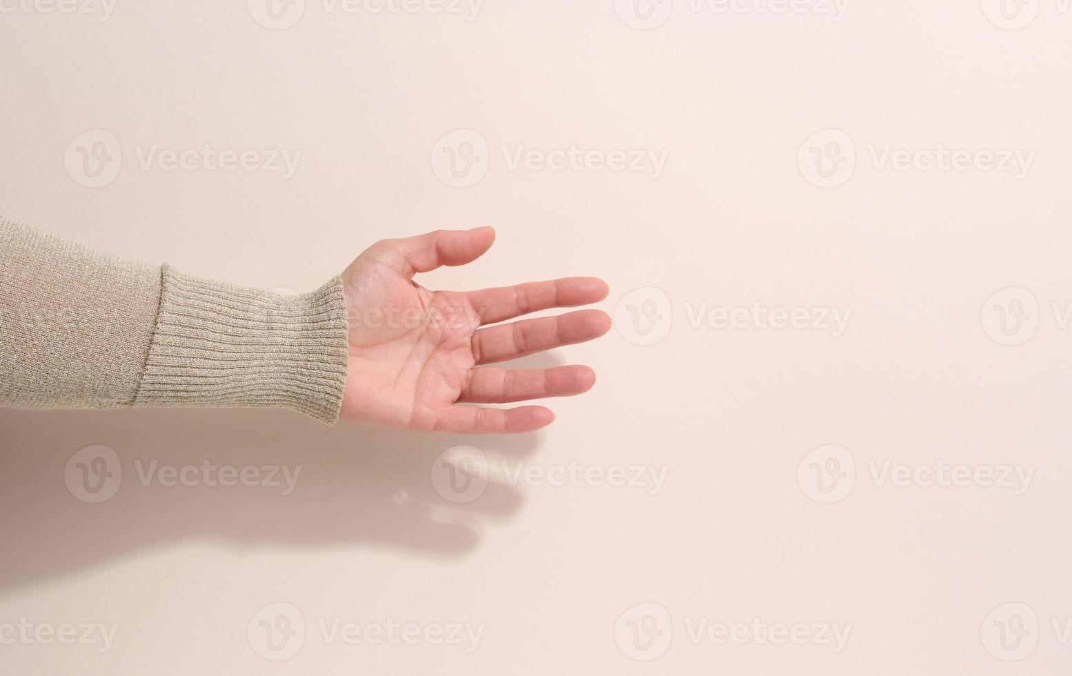 female teen hand to hold something on a beige background. Advertising and product promotion photo