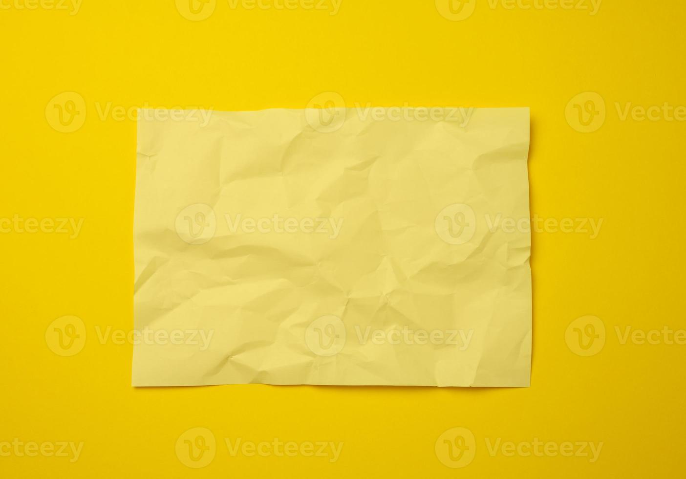 blank crumpled yellow sheet of paper on a yellow background 19034812