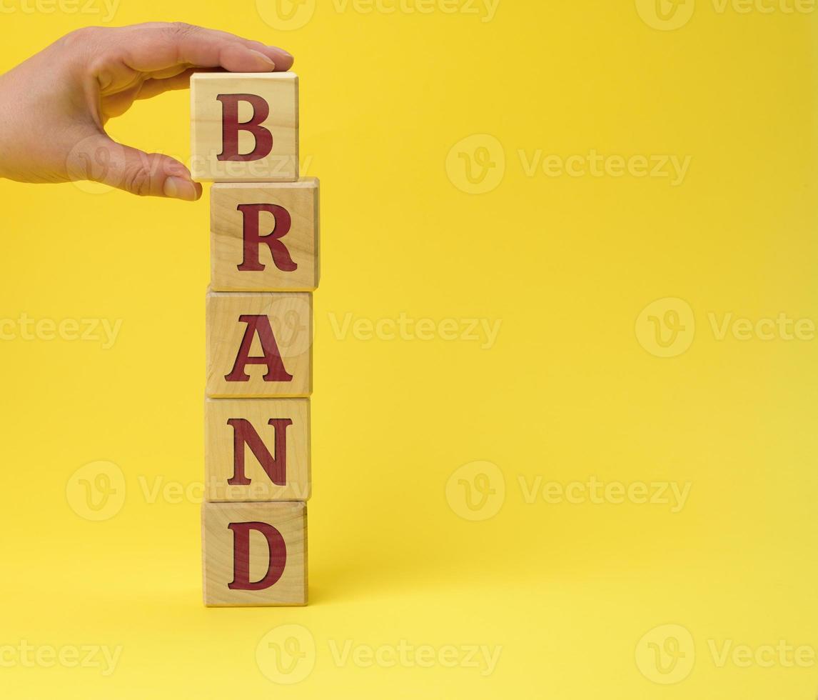 wooden blocks with the inscription brand on ayellow background photo