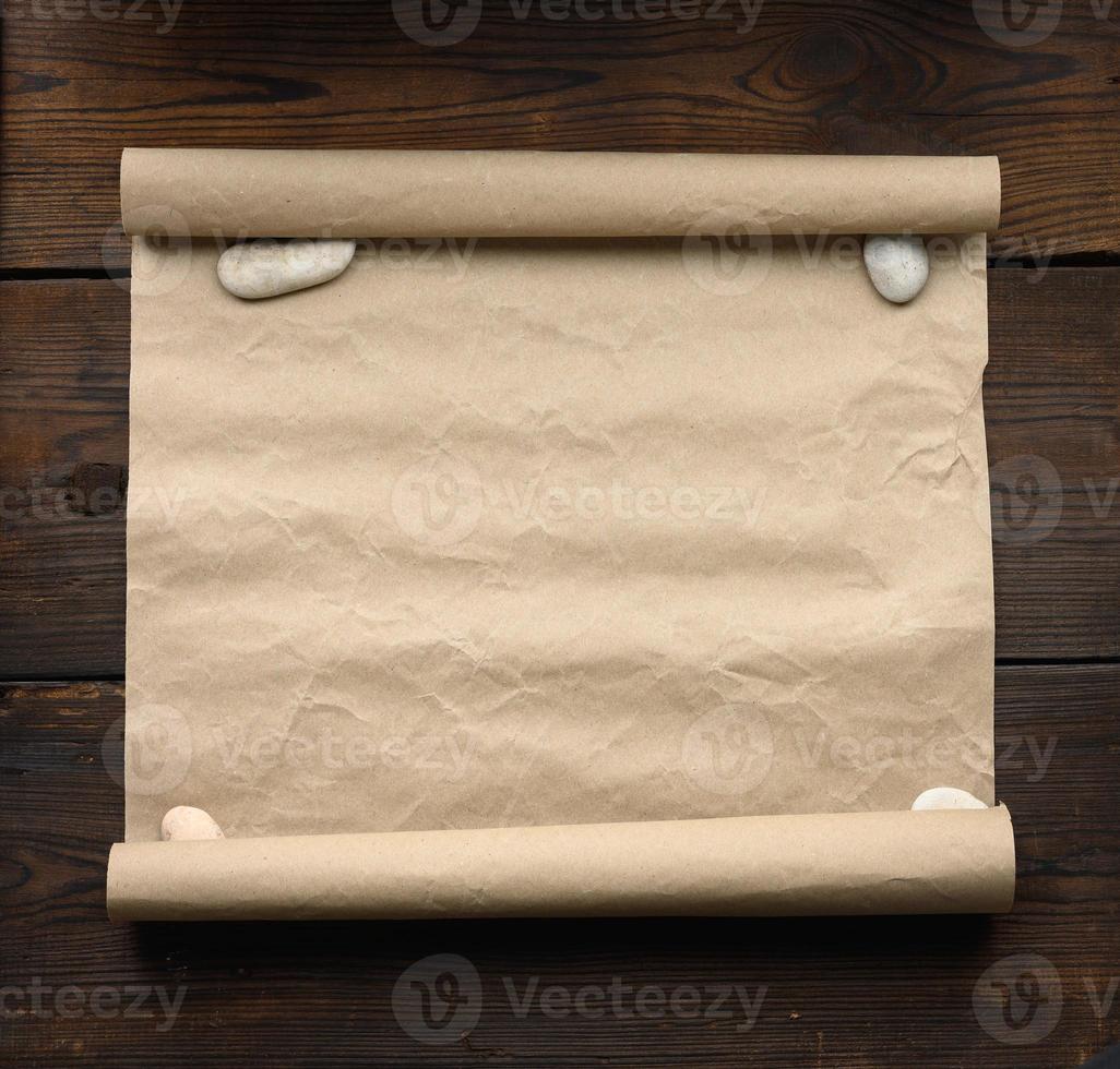 roll of brown kraft paper on a wooden background. Place for an inscription photo