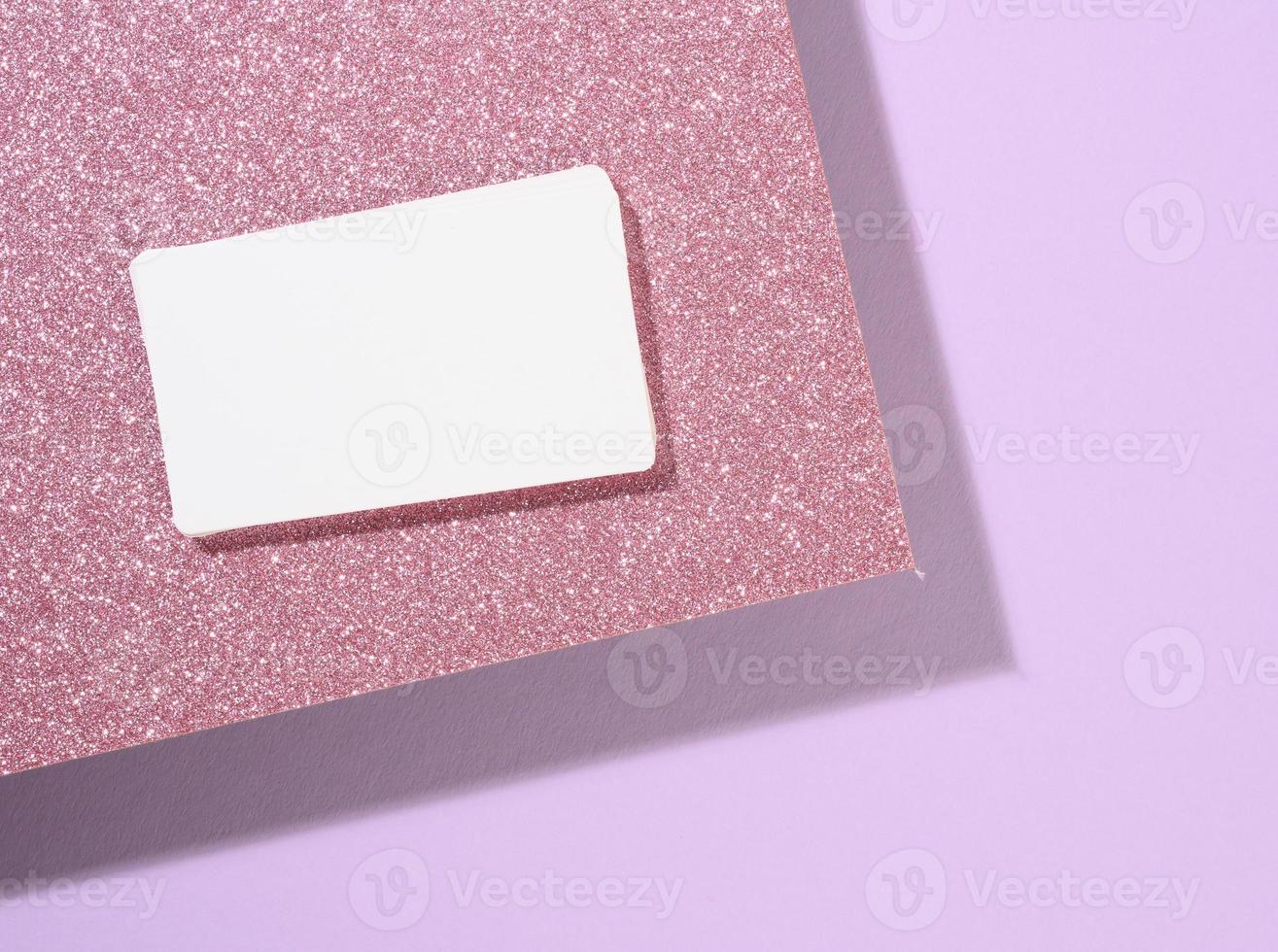 la tarjeta de visita rectangular en blanco se encuentra sobre un moderno fondo morado hojas de papel con una sombra foto