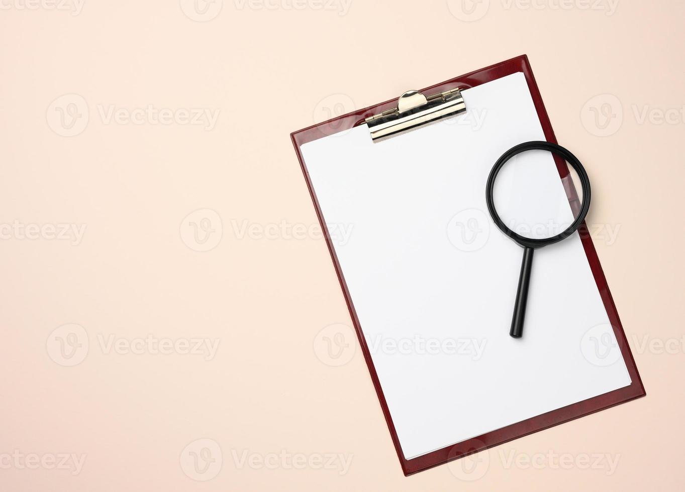 folder with blank white sheets and a black magnifier on a beige background. Background for inscriptions photo