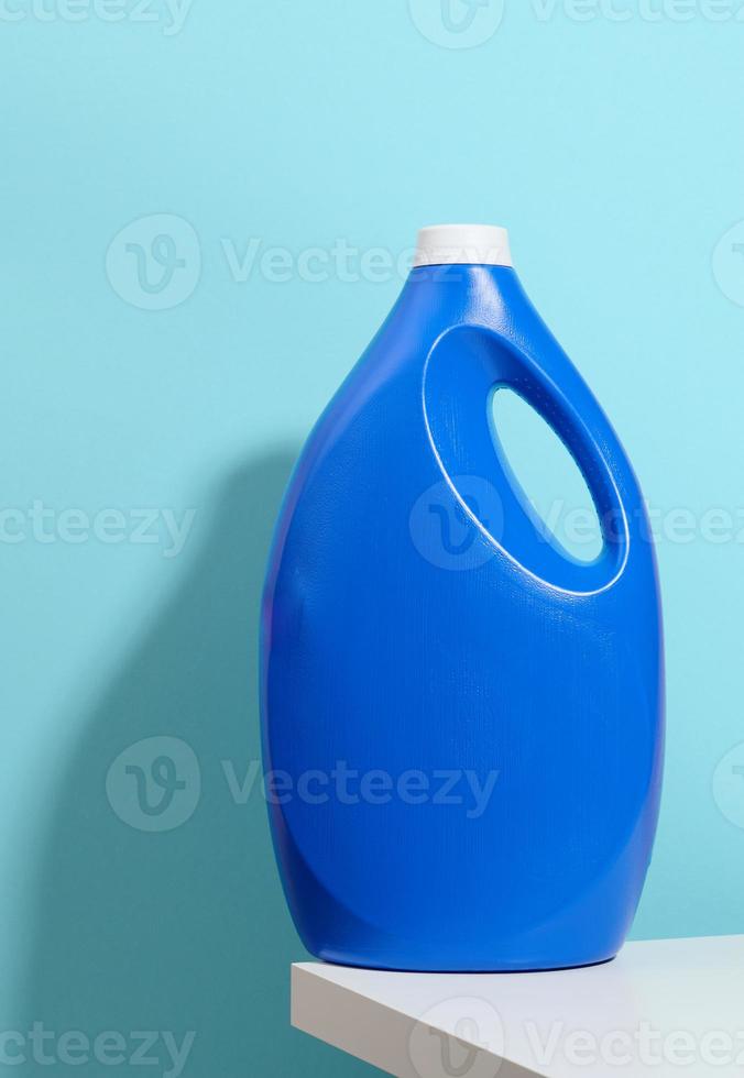 blue plastic bottle for liquid washing powder on a white table photo
