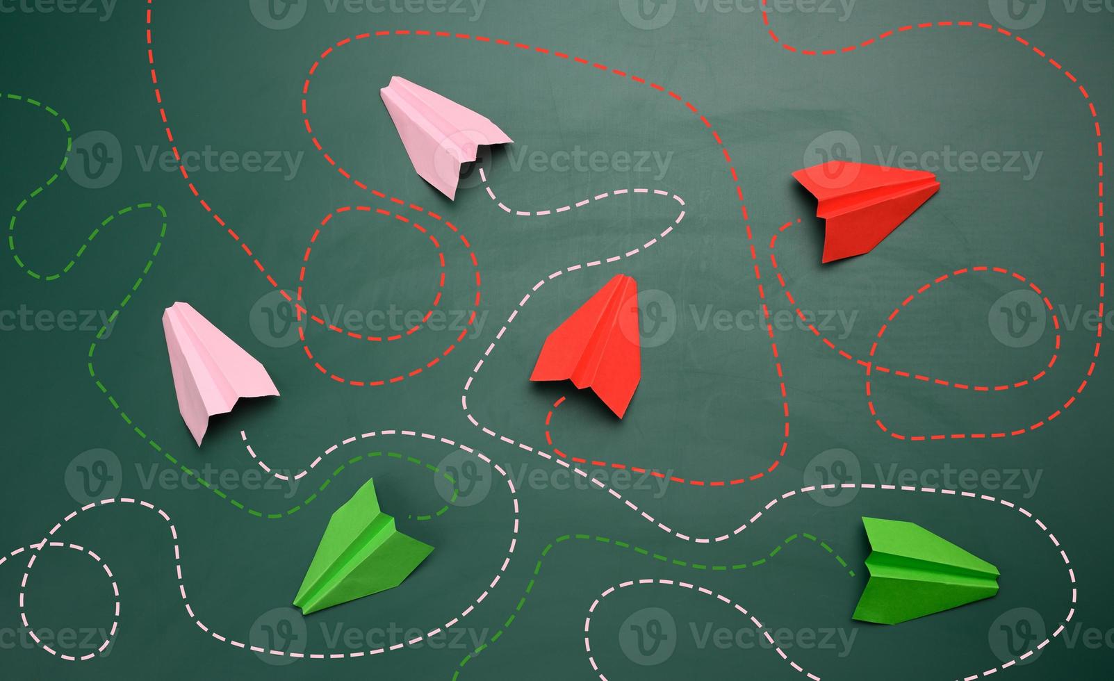 group of paper planes with long tangled paths on a green background. concept of a strong leader with extraordinary thinking, quick decision-making photo