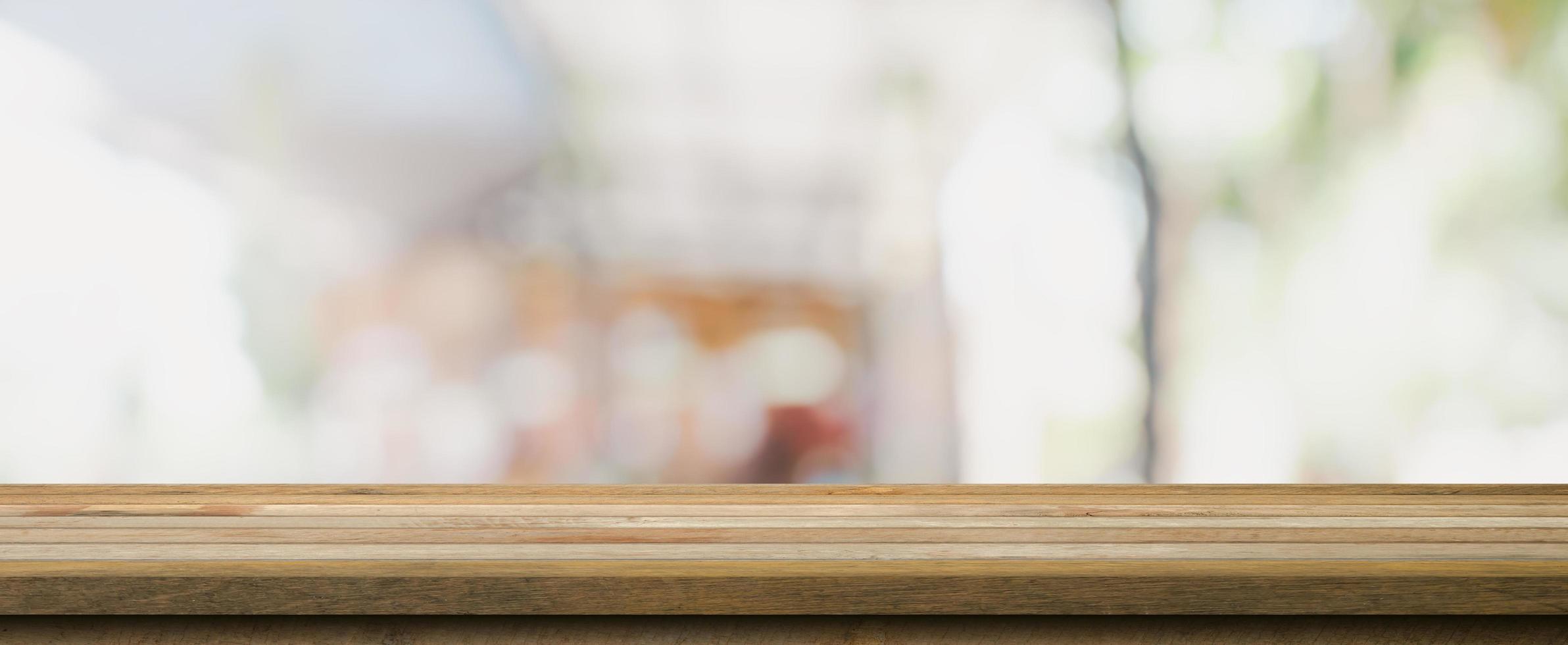 Wooden table top with blurred people in coffee shop and cafe background for display montage, copy space. photo