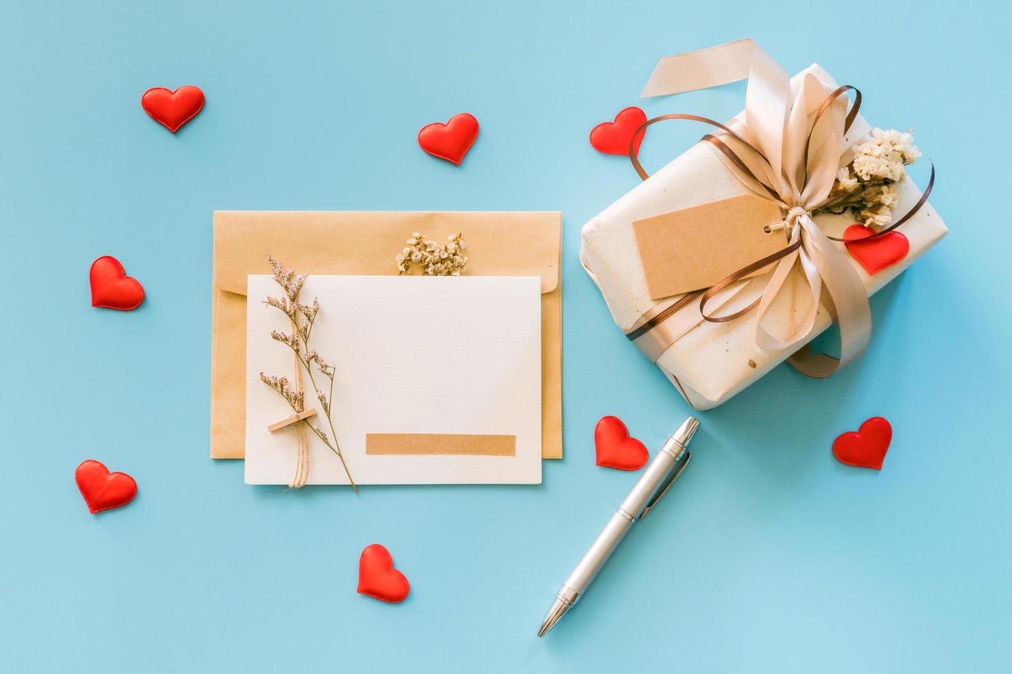 tarjetas de felicitación y cajas de regalo con corazón rojo sobre fondo azul, espacio para copiar texto foto