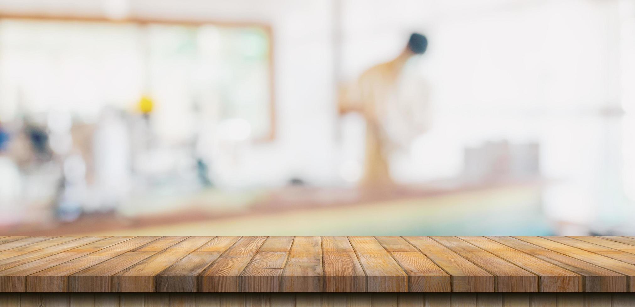 Wooden table top with blurred people in coffee shop and cafe background for display montage, copy space. photo