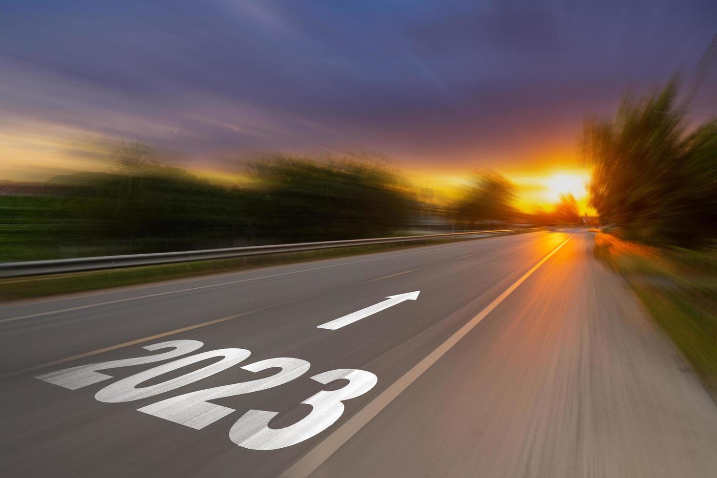 Motion blur empty asphalt road and New year 2023 concept. Driving on an empty road to Goals 2023 with sunset. photo