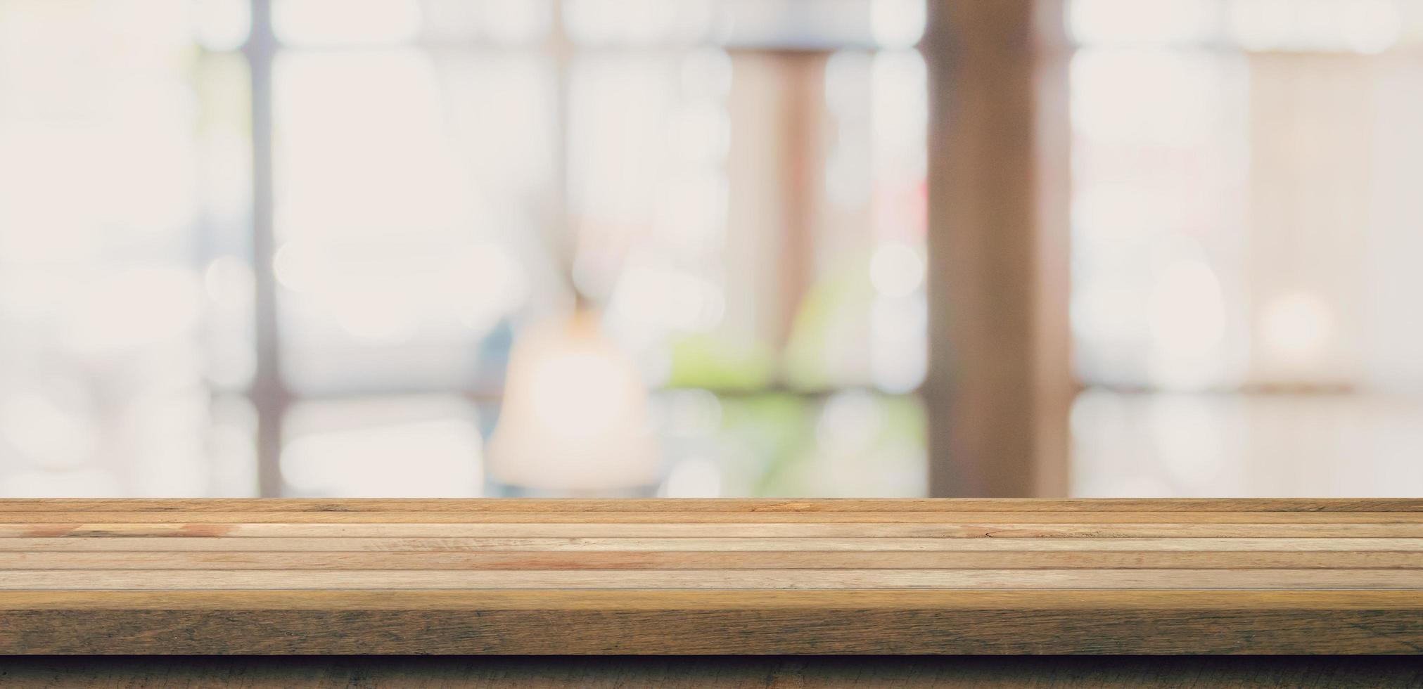 Wooden table top with blurred people in coffee shop and cafe background for display montage, copy space. photo