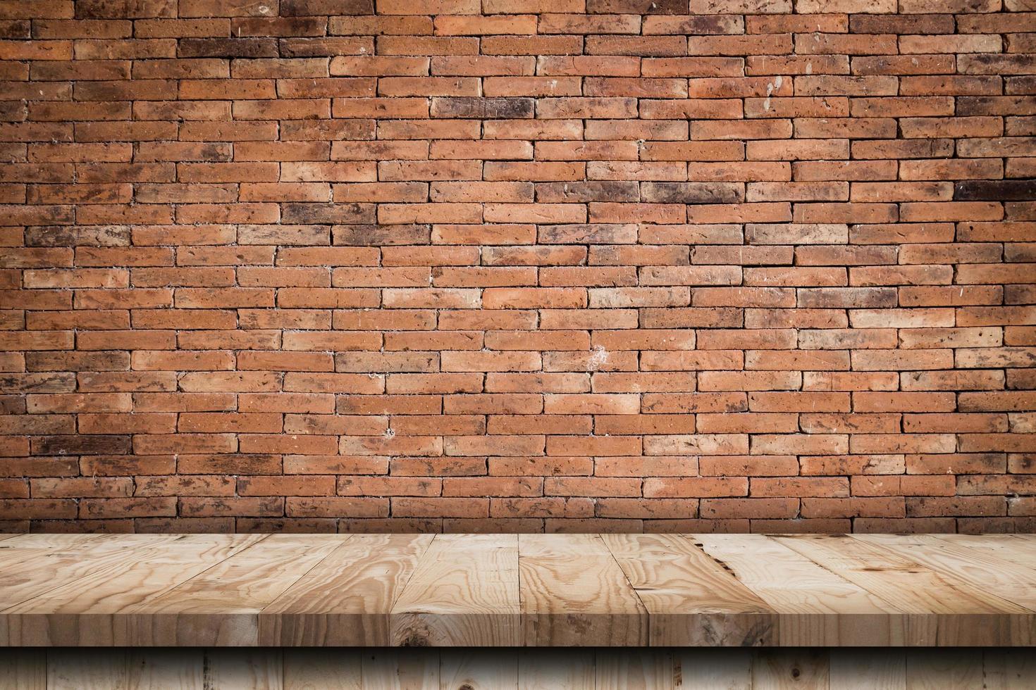 Empty wooden table top and red brick wall and rough crack background texture photo