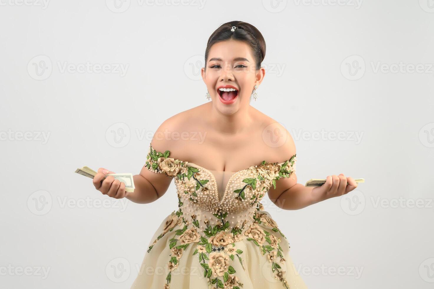 Young asian beautiful bride holding dollar bills in hand photo