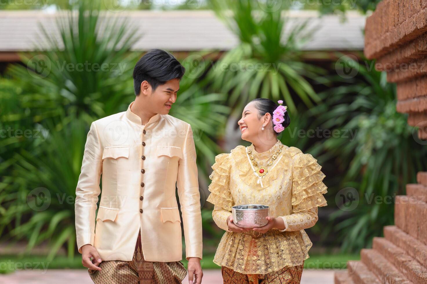 pareja joven sosteniendo un cuenco de agua en el festival de songkran foto