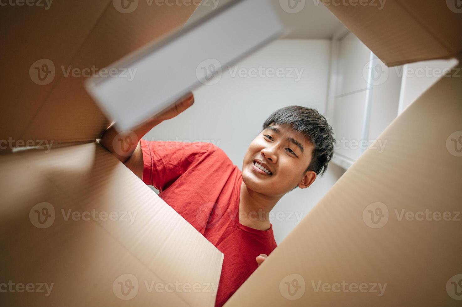 Young man opening parcel pick up book out of box photo