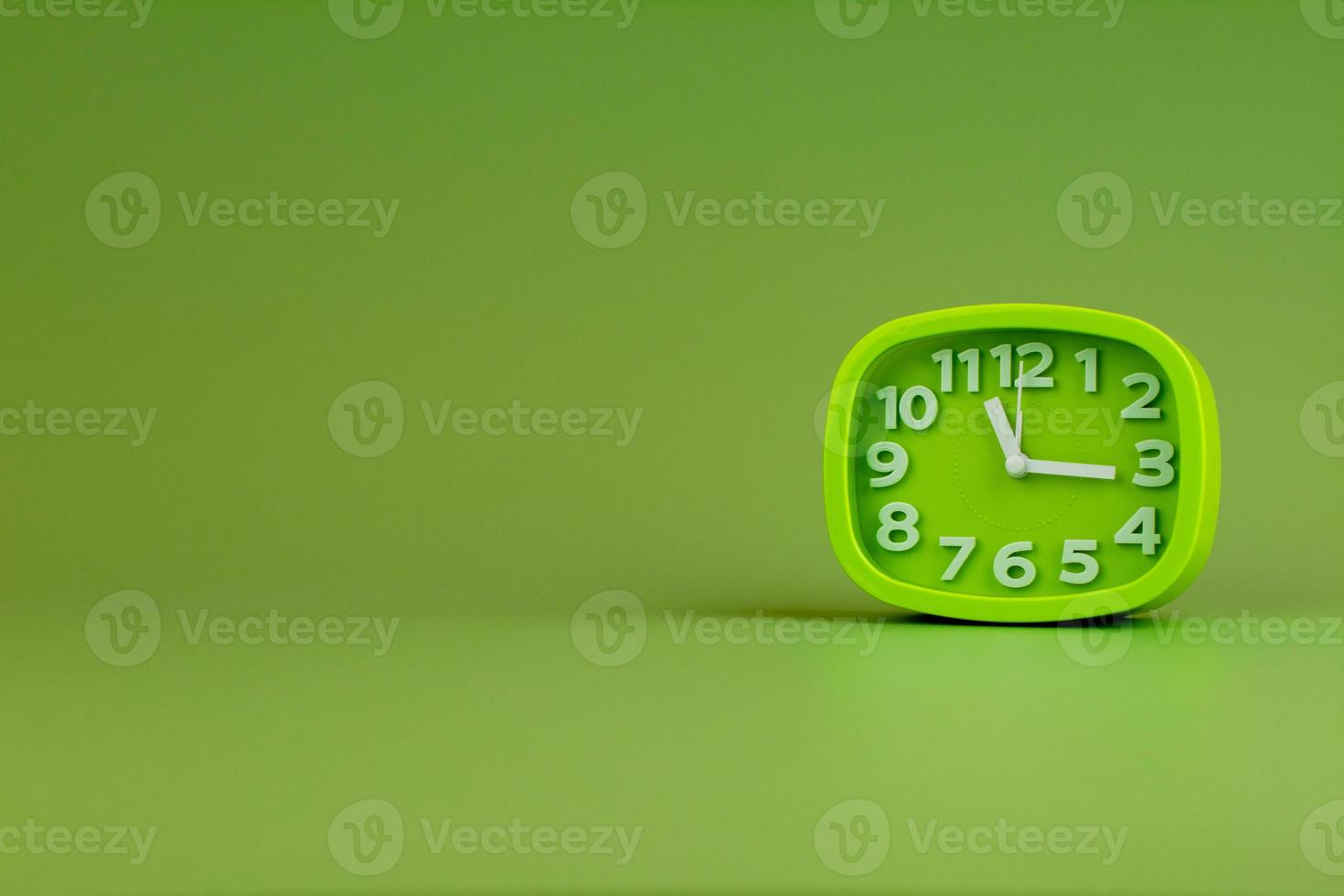 Alarm clock on green background, time concept, clock photo