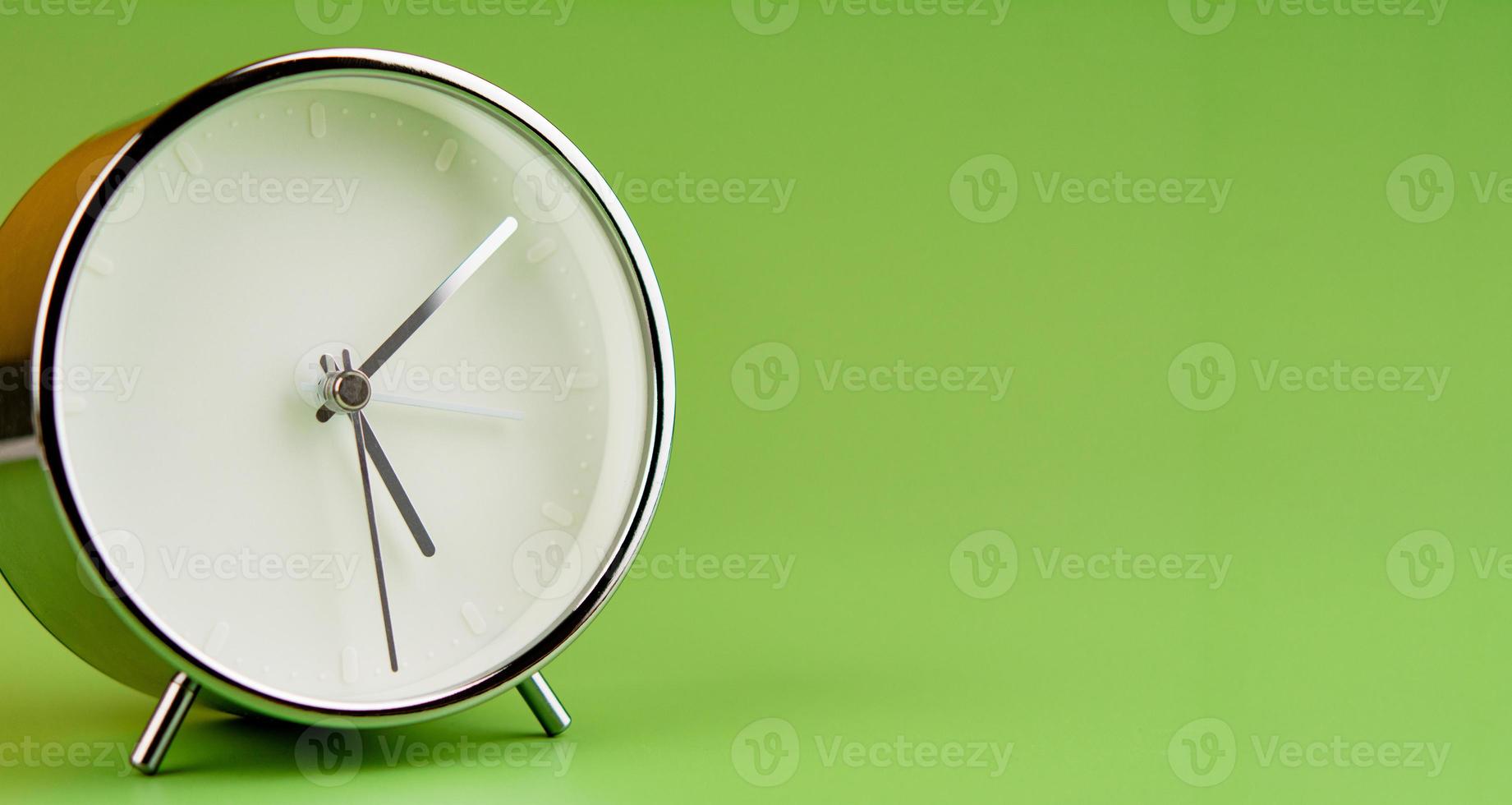 Alarm clock on green background, time concept, clock photo