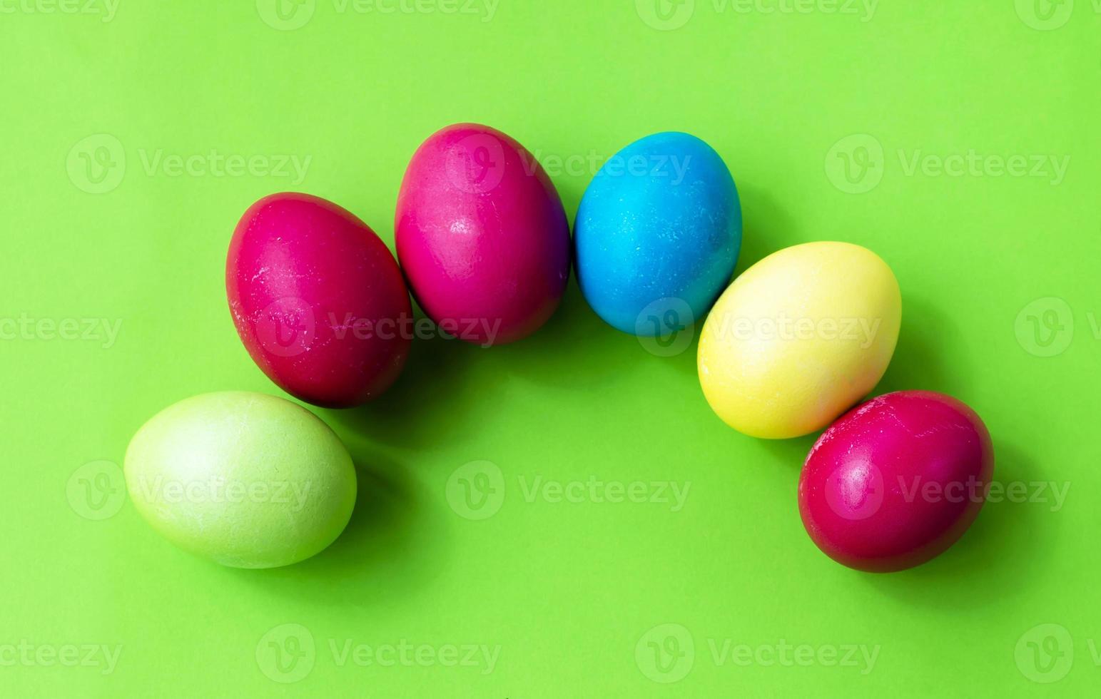 huevos de Pascua coloridos sobre un fondo verde. tarjeta postal. felicitaciones foto