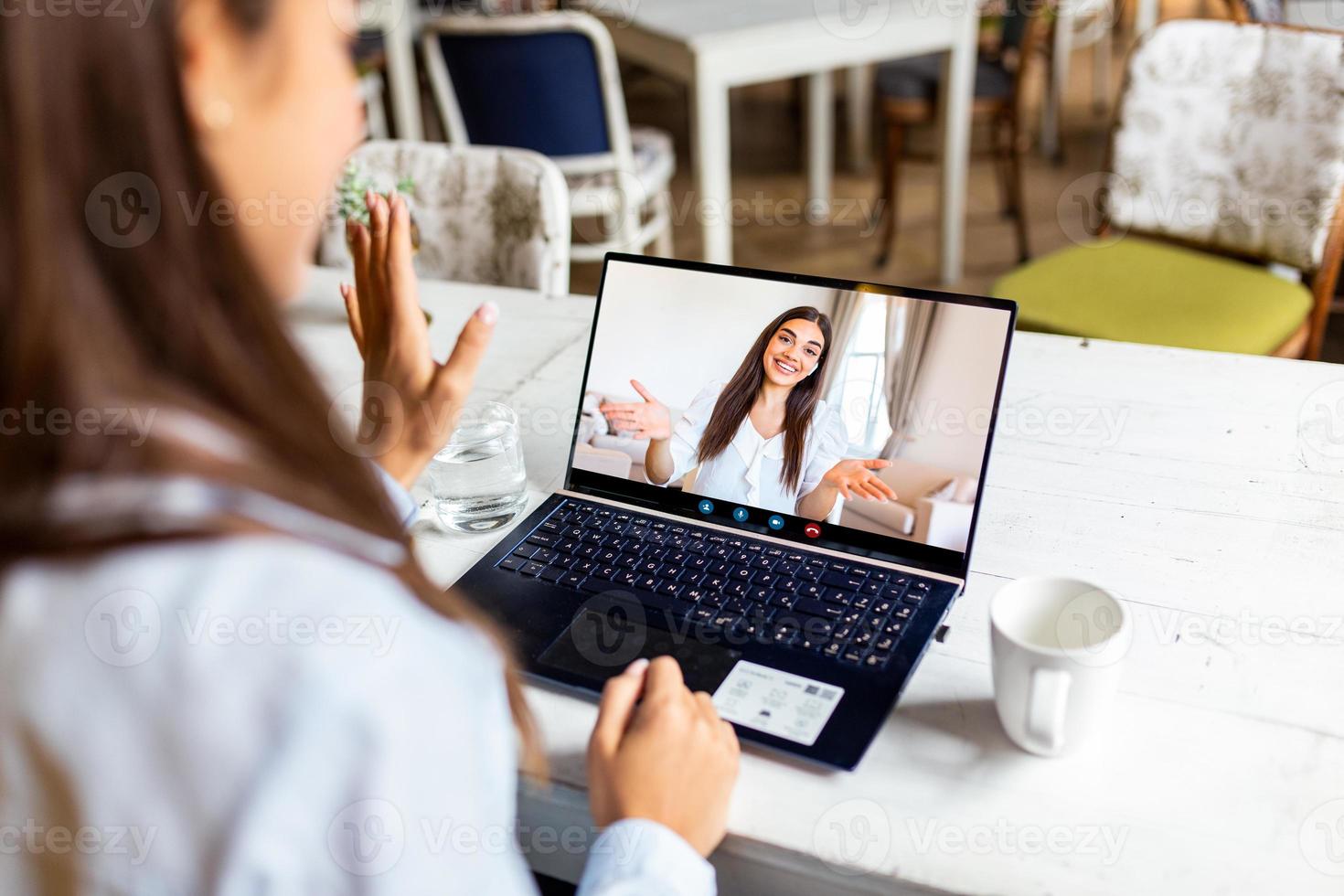 vista posterior de la niña relajarse en el restaurante hablar en una videollamada con una hermana o amiga sonriente en cuarentena, una mujer joven se divierte chatear comunicarse en línea usar una conversación de cámara web en una computadora portátil moderna foto