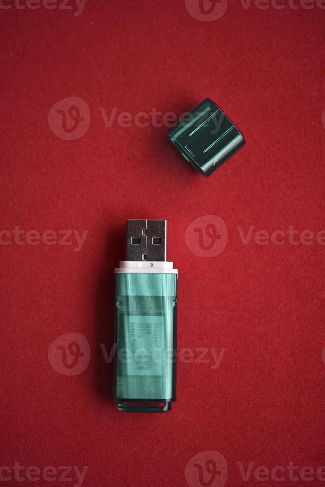 USB flash drive close-up on a red background. One USB flash drive with a lid. photo