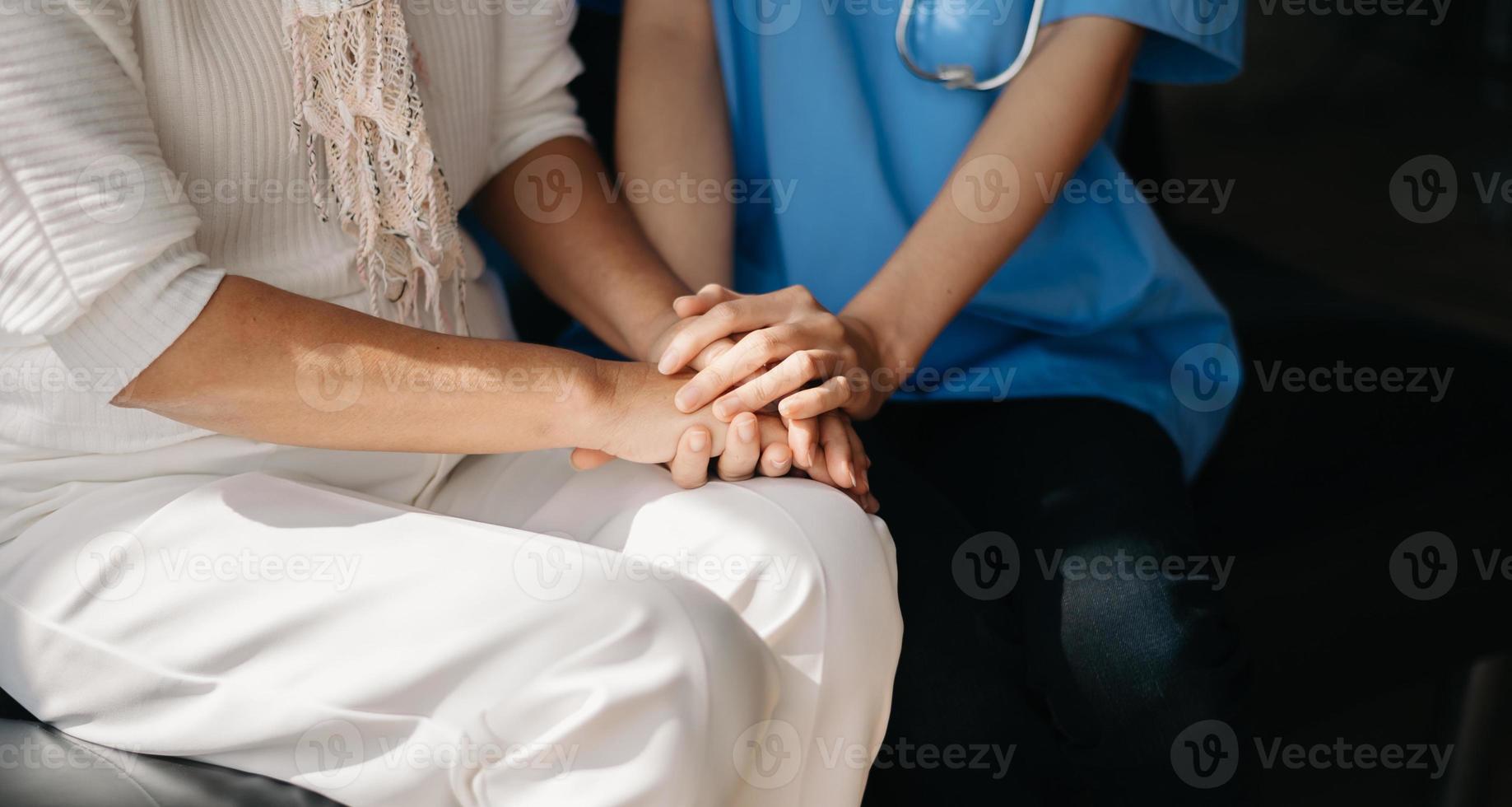 médico agujereando las manos de la paciente mayor y consolándola en casa foto