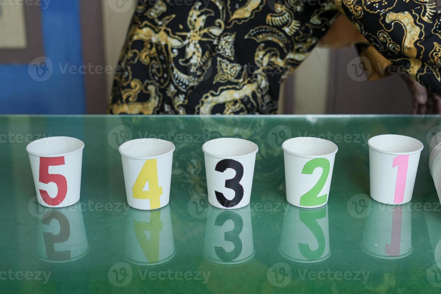 A game of numbers on glasses for early childhood using used glass media. There are numbers 1-5 with different color variants photo