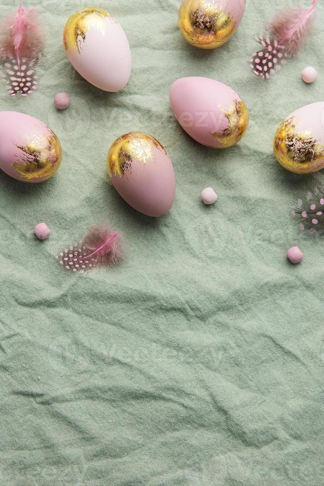 Easter eggs are painted with violet and green paint on a gray linen background. photo