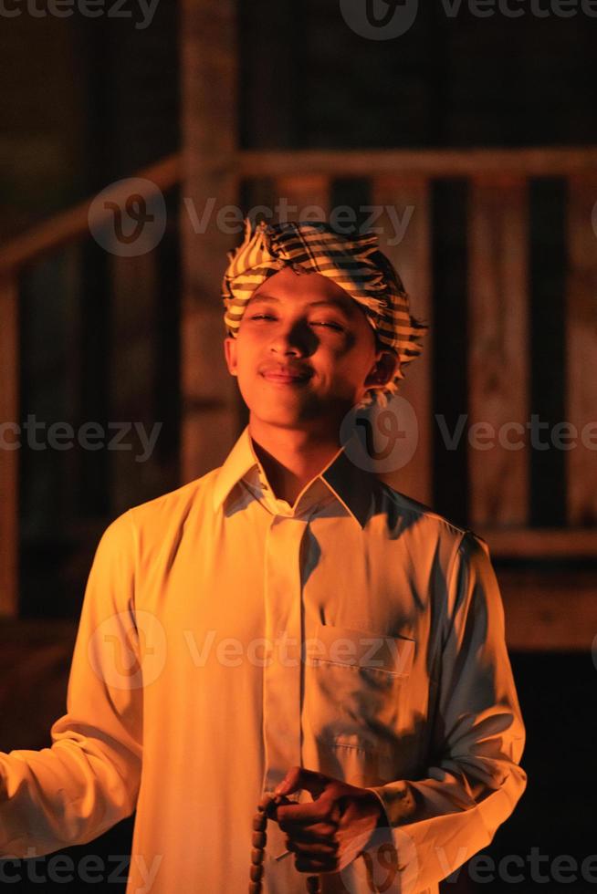 An Islamic man wearing a Muslim dress in the dark night with the fire torch lighting photo