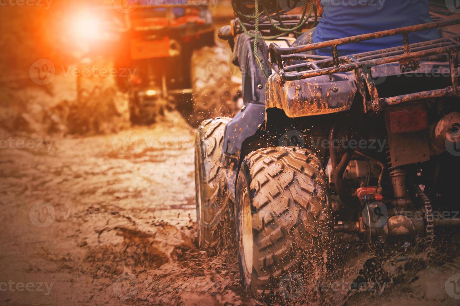 action shot of sport atv vehicle running in mud track photo