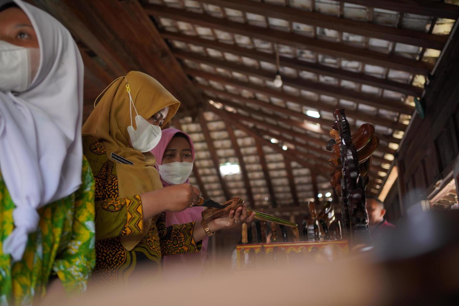 visitantes mirando una colección de kerises en una galería. bantul, indonesia - 25 agosto 2022 foto