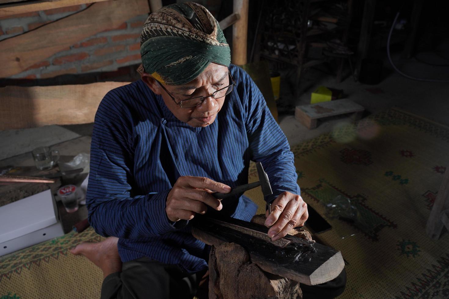 artesanos de keris en el taller, en el proceso de elaboración de keris. bantul, indonesia - 25 agosto 2022 foto