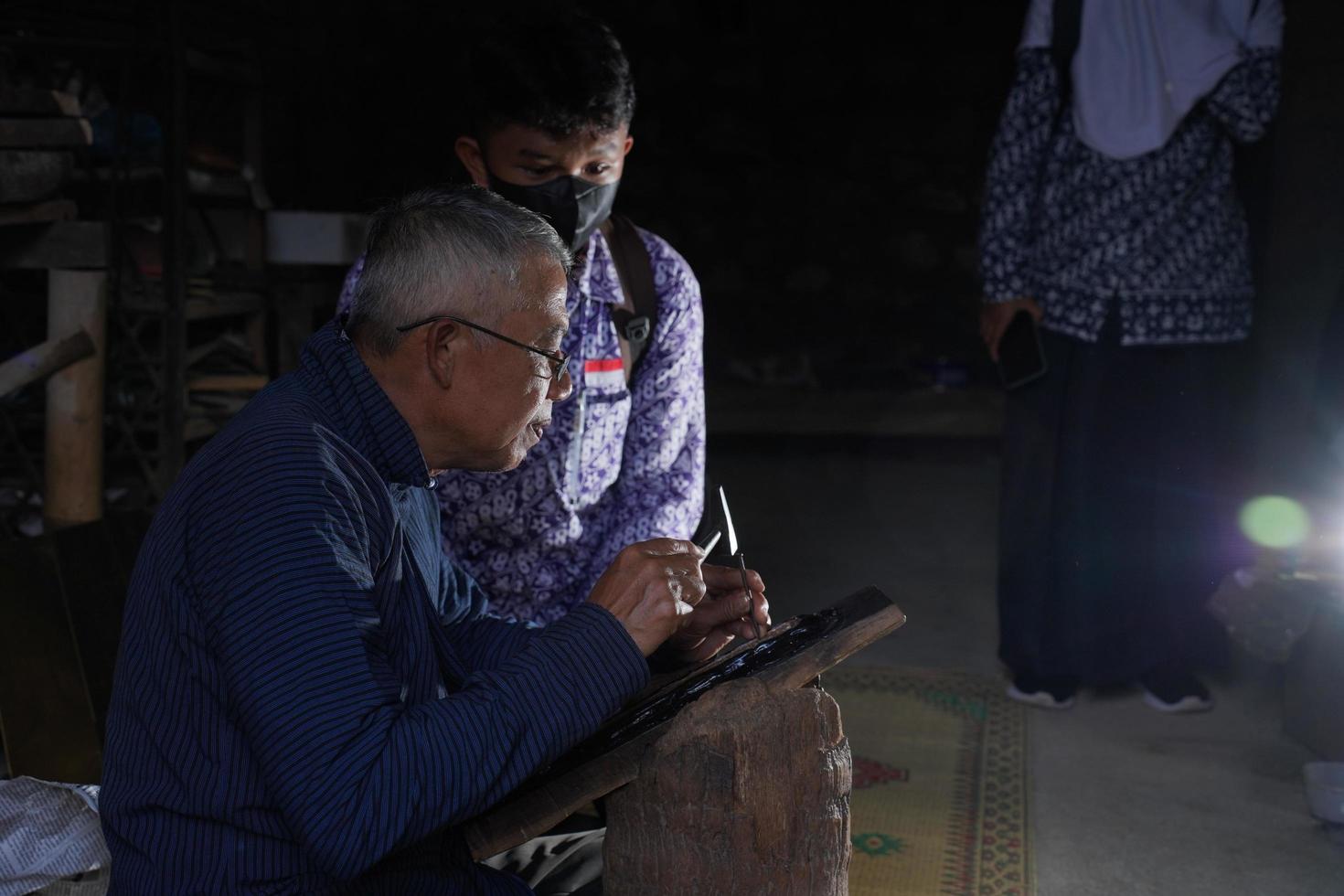 Keris craftsmen are teaching visitors about the process of making keris in the workshop. Bantul, Indonesia - 25 August 2022 photo