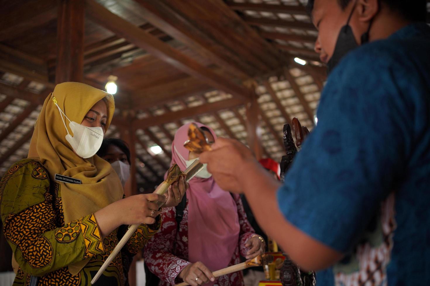 visitantes mirando una colección de kerises en una galería. bantul, indonesia - 25 agosto 2022 foto