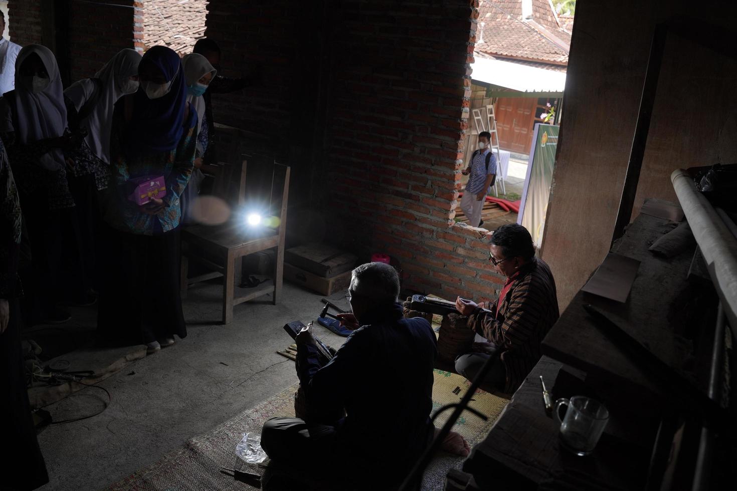 Los artesanos de keris están enseñando a los visitantes sobre el proceso de elaboración de keris en el taller. bantul, indonesia - 25 agosto 2022 foto