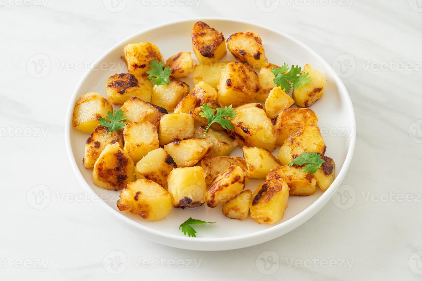 Roasted or grilled potatoes  on plate photo