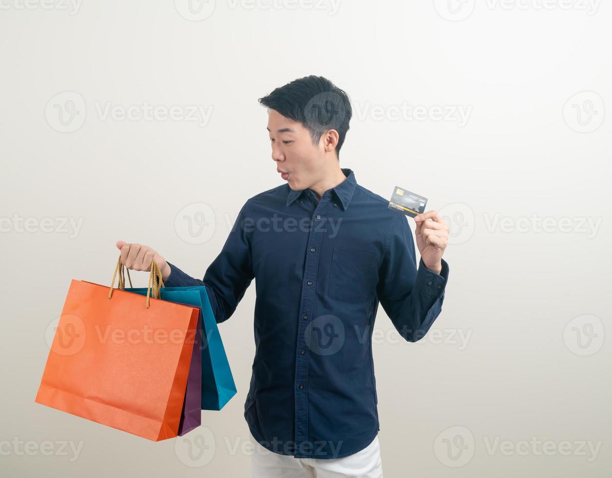 retrato, joven, asiático, hombre, tenencia, tarjeta de crédito, y, bolsa de compras foto