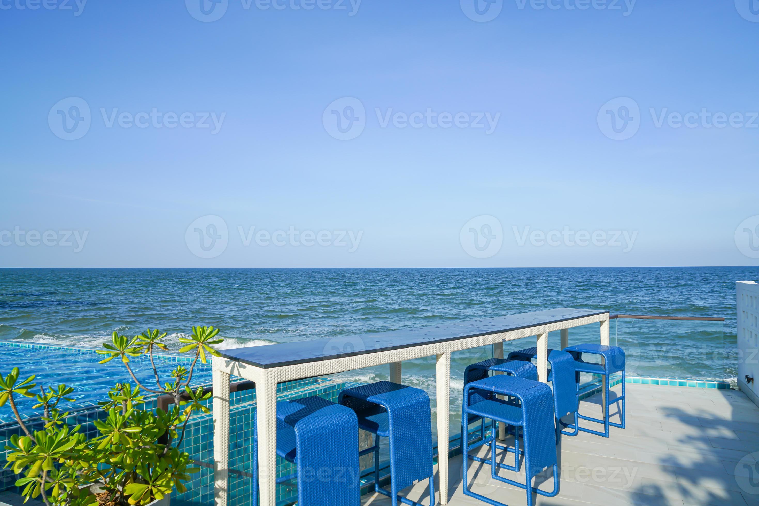 desk and bar stool near swimming pool with sea background 19048174