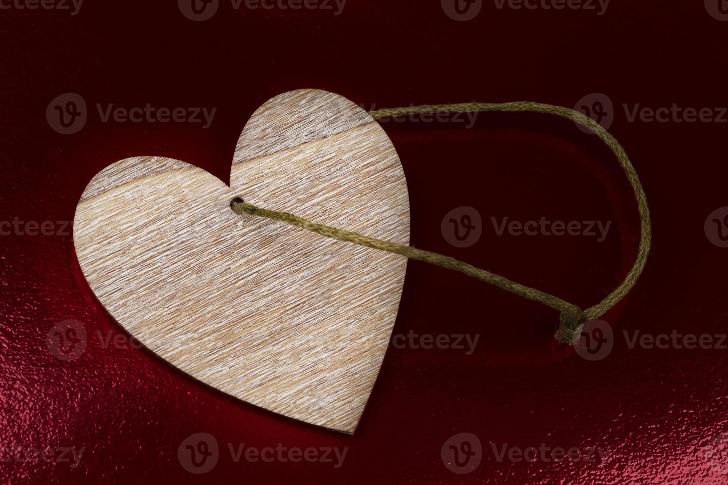 Vintage heart made of wood on a dark red background. photo