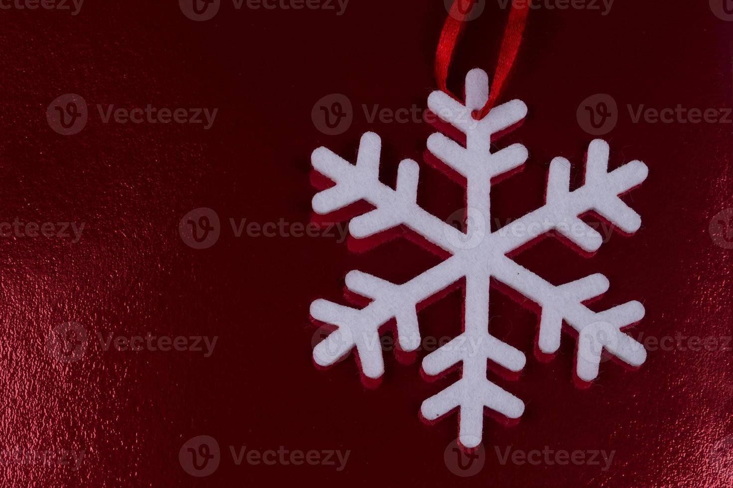 White snowflake on a red shiny christmas background. photo