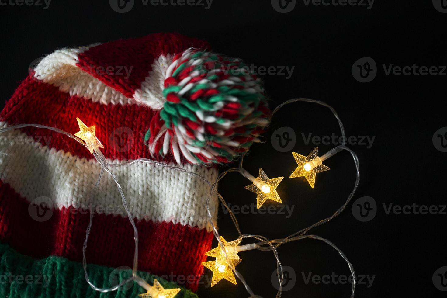 fondo de navidad con un sombrero de navidad y guirnaldas de colores. foto