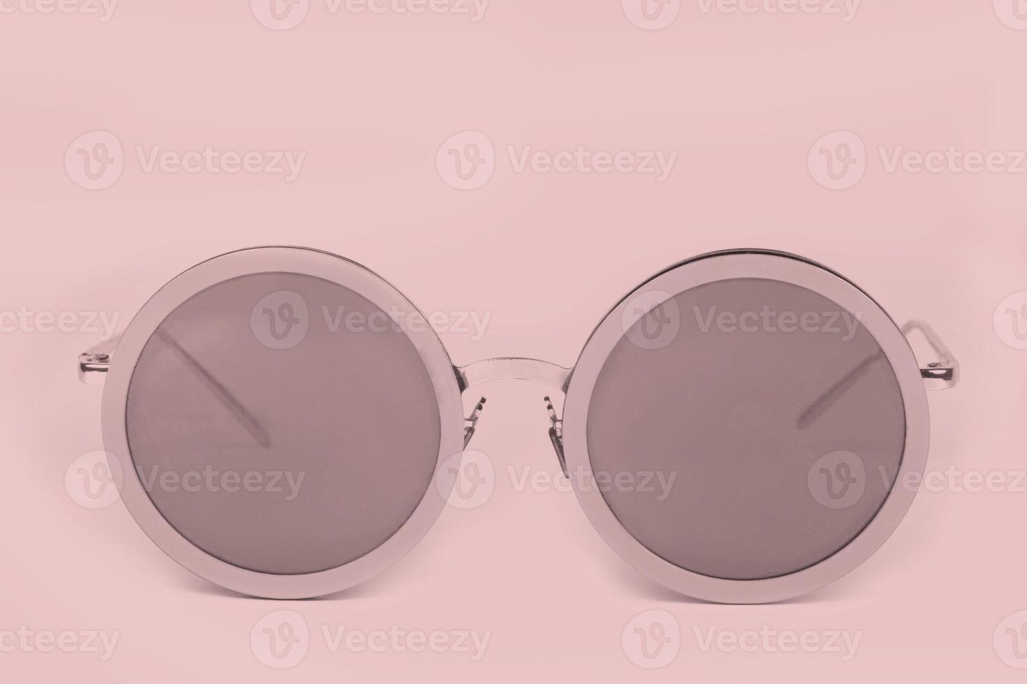 Pink sunglasses on a pink background. photo