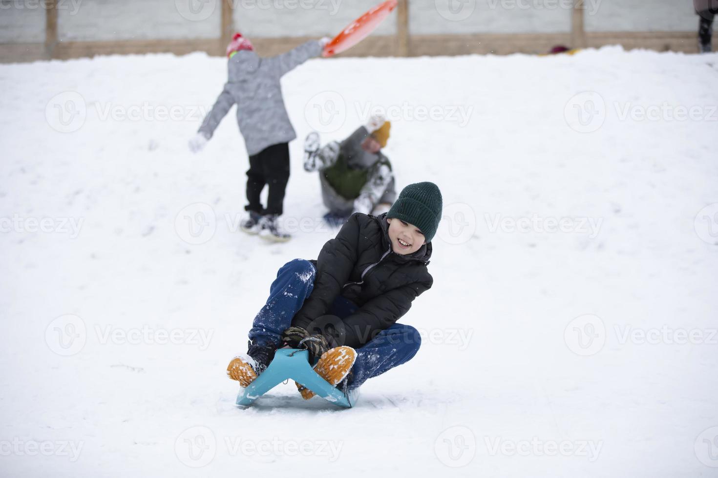 Children in winter. Boys friends are sledding. photo