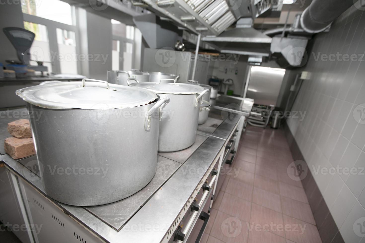 Industrial kitchen with large metal pans. photo