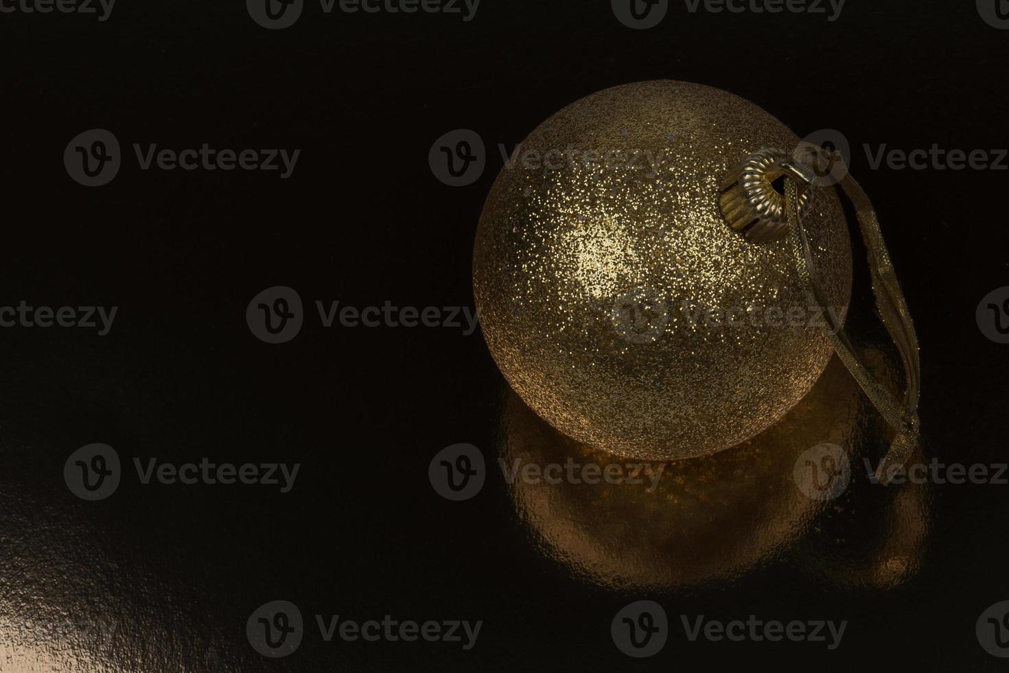 Golden Christmas ball on a black background. photo